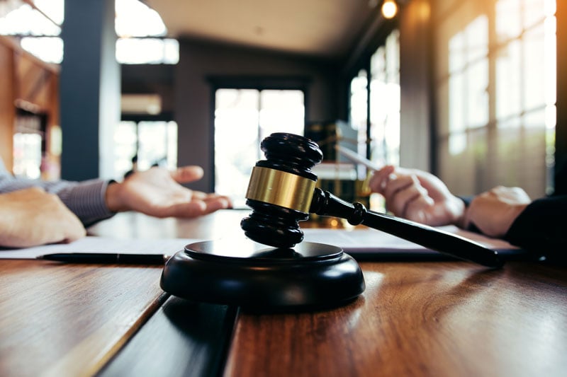 Plymouth lawyer reviewing personalized case strategies with a client at a law firm office desk.