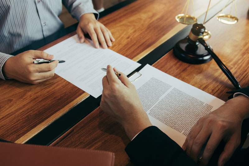 Canton Township lawyer reviewing personalized case strategies with a client at a law firm office desk.