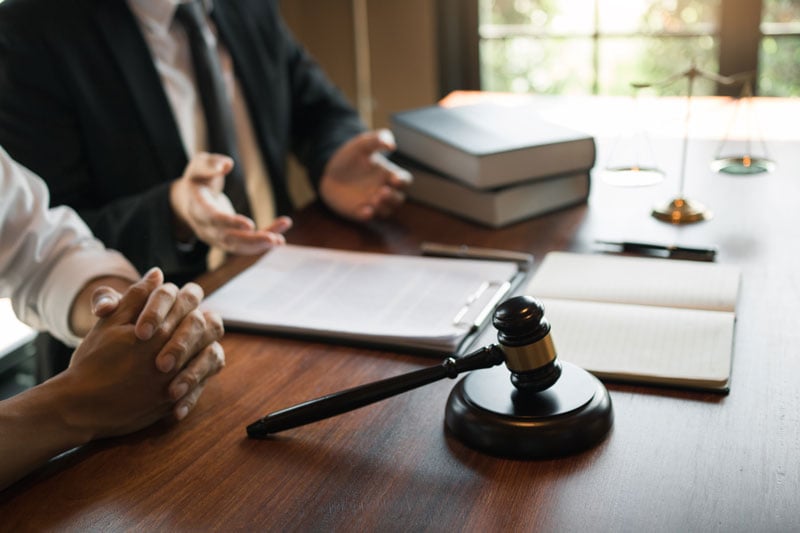 Southfield lawyer reviewing personalized case strategies with a client at a law firm office desk.