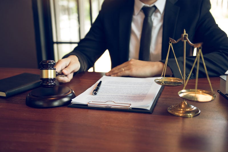 West Bloomfield lawyer reviewing personalized case strategies with a client at a law firm office desk.