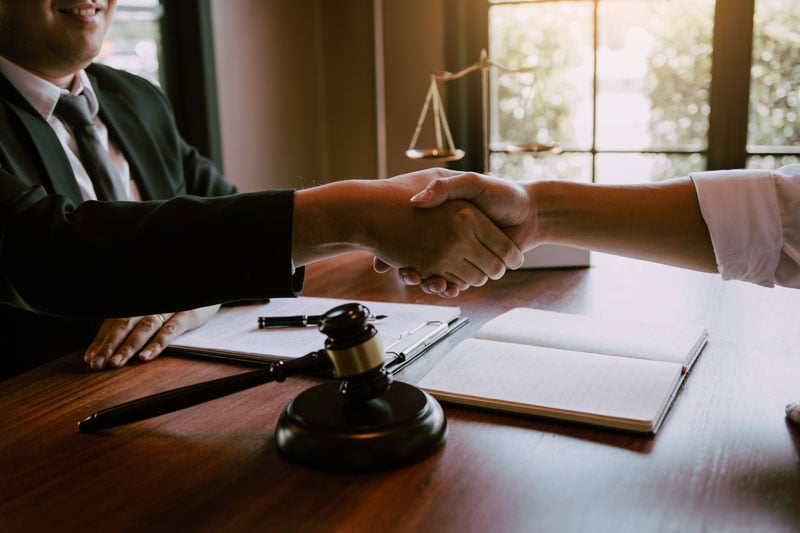 Novi lawyer reviewing personalized case strategies with a client at a law firm office desk.